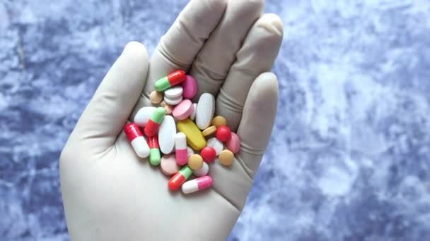 Píldoras médicas coloridas y cápsula en la mano — Vídeos de Stock