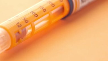 Turuncu arka planda insülin kalemler, kapatın 