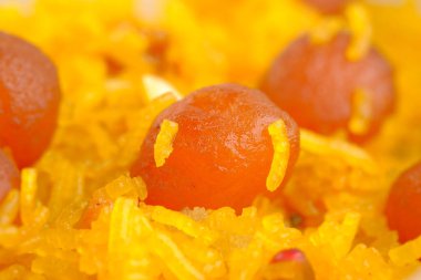 Masadaki bir kasede Hint tatlısına yaklaş..