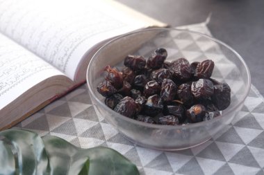 Taze meyveyi bir kâsede ve Kuran 'ı masada yakın. 