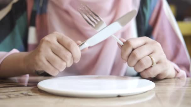 Vrouwen hand vasthouden bestek met lege plaat wachten op voedsel — Stockvideo