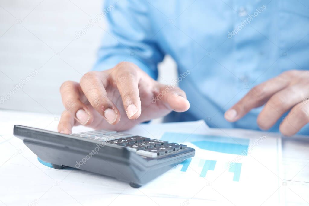 Close up of man hand using calculator 