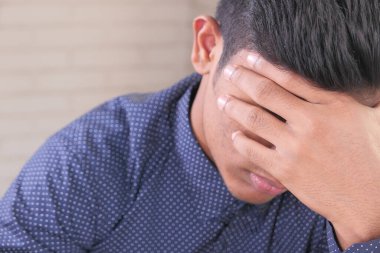 Üzüntülü adamın yüzünü ellerinle kapat..