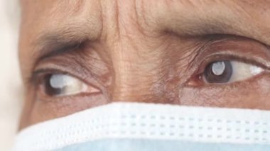 Yüz maskeli yaşlı Asyalı kadınların gözlerini kapat.