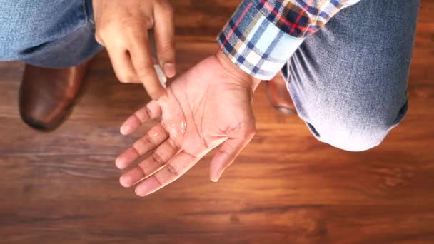 Draufsicht auf die Hand eines jungen Mannes mit Händedesinfektionsspray. — Stockvideo