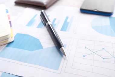 finansal grafik, hesap makinesi ve not defteri masanın üzerinde 