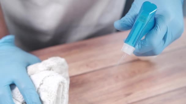 Main en gants de caoutchouc bleu tenant le flacon pulvérisateur avec espace de copie — Video