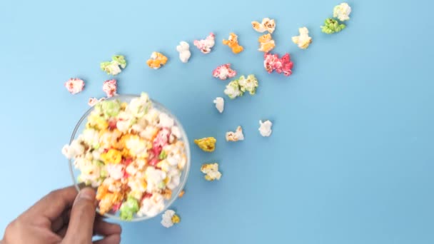 Покласти миску попкорну на кольоровий фон — стокове відео