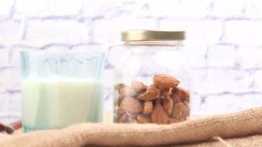  Kavanozda badem fıstığı ve masada bir bardak süt. 