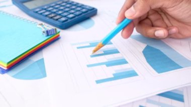 Kalem çizelgesini kağıt üzerinde analiz eden bir adam. 