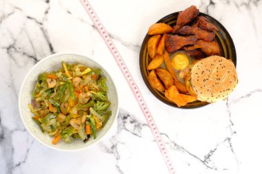 abur cubur, pişmiş sebze ve ahşap masada mezura.