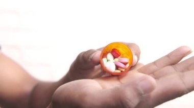 İlaç kutusundan dökülen ilaçlı adam eli. 