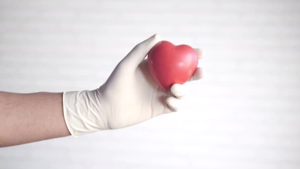 Man hand in protective gloves holding red heart — Stock Video