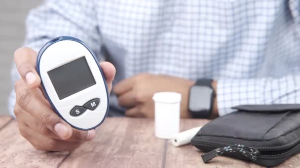 Człowiek trzymający na stole narzędzia do pomiaru cukrzycy — Wideo stockowe