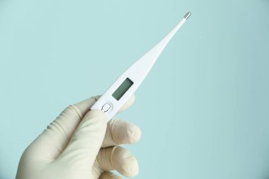 Dijital termometre tutan lateks eldivenli adama yaklaş..