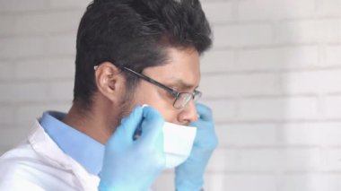 İçeriye cerrahi maske takan genç bir doktorun yan görüntüsü 