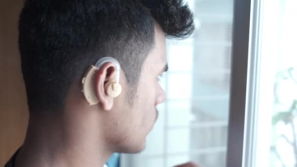 Концепція слухового апарату, молодий чоловік з проблемами слуху . — стокове відео