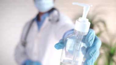 Doktor elinde dezenfektan jel tutan lateks eldivenler getirdi. 