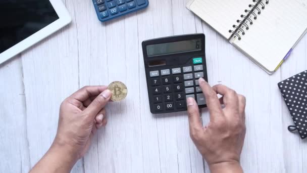 Celebración de bitcoins de oro y escribir en la calculadora — Vídeos de Stock