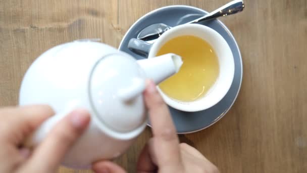 Teát töltök egy teaszertartásról a fa asztalra. — Stock videók