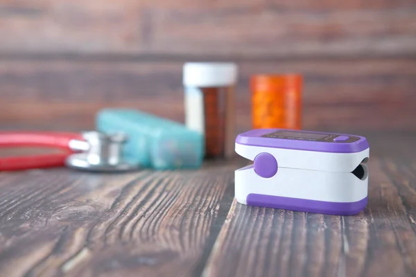 pulse oximeter and medical container on table