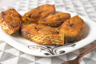 Tabaktaki pişmiş ilsha balığını yakın. 