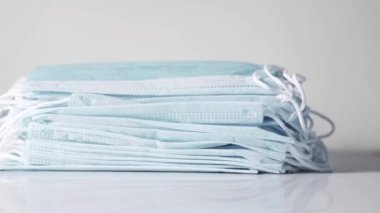 Turuncu arka planda cerrahi maskeler, termometre ve el dezenfektanı. 