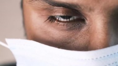 Genç Asyalı adam cerrahi yüz maskesi takıyor. 