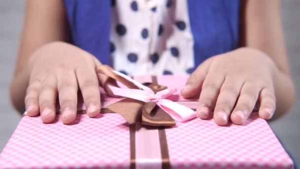 Concepto del día de la madre del niño sosteniendo la mano caja de regalo de color rosa — Vídeos de Stock