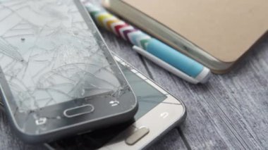 Ahşap arka planda kırılmış akıllı telefonu kapat 