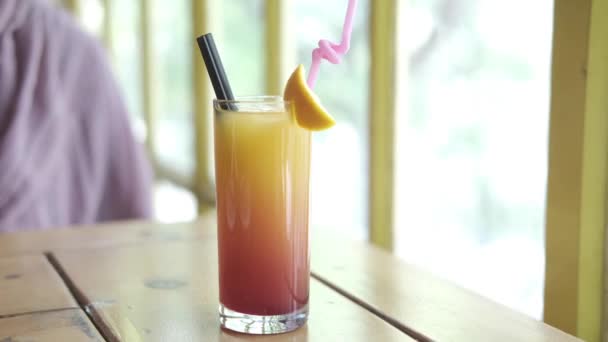 Стакан апельсиновых напитков на столике в кафе — стоковое видео