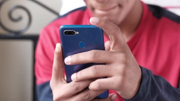 Young man hand using smart phone sitting on bed — Stock Video