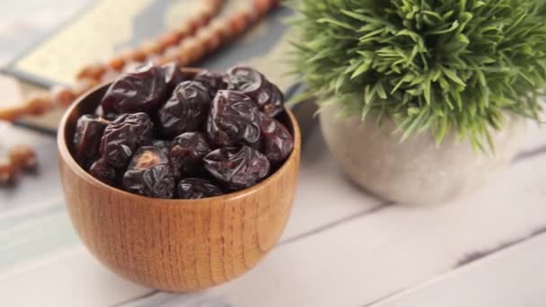 Close up of fresh date fruit in a bowl and a quran on table — Stock Video