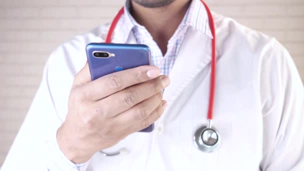 Arts in witte jas met behulp van een smartphone. — Stockvideo