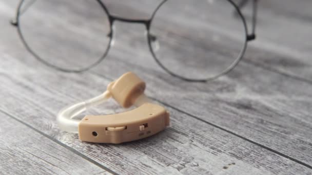 Hearing aid equipment on wooden background — Stock Video