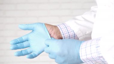 Doktor tıbbi lateks eldiven takıyor, yakın çekim.