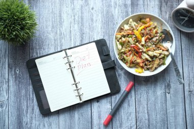 Not defterine el yazısı diyeti ve tabakta taze salata. 