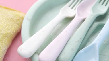 Sünger, lastik eldiven ve pembe renkli tabak. 