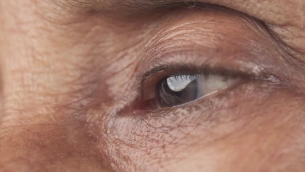 Detalhe tiro de mulheres seniores olhos olhando para longe — Vídeo de Stock