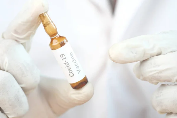 Mão em luvas de látex segurando vacina ampola de vidro, com espaço de cópia — Fotografia de Stock