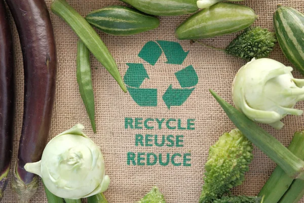 Flèches recyclées signe sur un sac à provisions avec des légumes — Photo