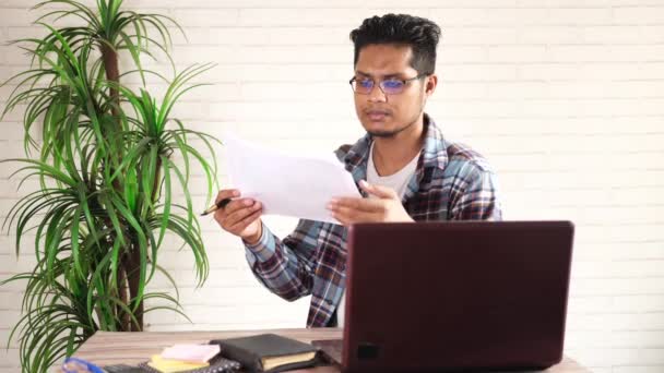 Mladý asijský muž analyzující data na papíře pracující na stole — Stock video