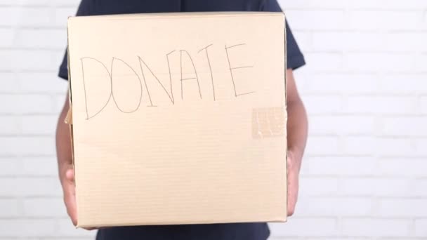 Joven sosteniendo caja de donación — Vídeo de stock