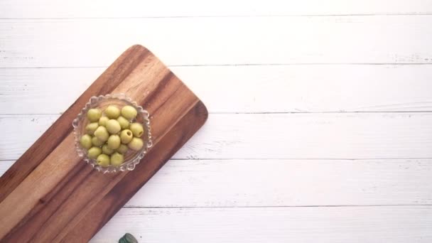 Botella de aceite de oliva y oliva fresca en un recipiente sobre tabla de picar . — Vídeo de stock