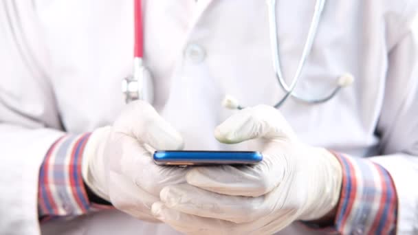 의사가 스마트폰 문자 메시지를 사용하여 의료 장갑을 끼는 모습 — 비디오
