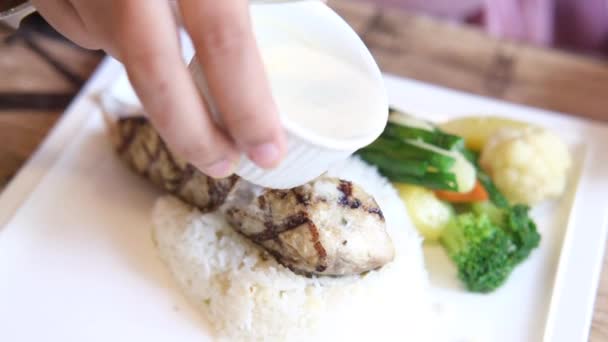 Poner mayonesa en el filete de pescado a la parrilla con ensalada fresca en el plato de cerca — Vídeos de Stock