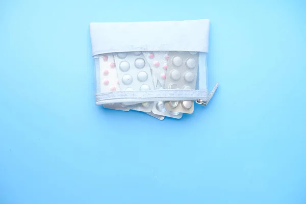 Pillen van blisterverpakking in een zakje op blauwe achtergrond — Stockfoto
