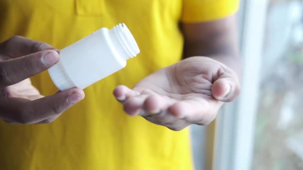 Mans mano con la medicina derramada fuera del envase de la píldora — Vídeo de stock
