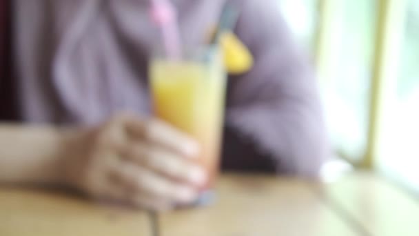Kobiety trzymające szklankę soku pomarańczowego w kawiarni — Wideo stockowe