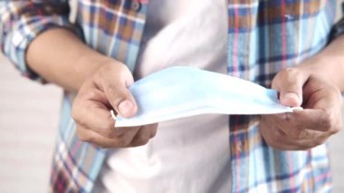  Adam elinde cerrahi maske tutuyor, yakın plan. 